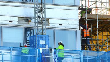 Workmen remove the cladding from the facade of a block of flats in Paddington, north London.